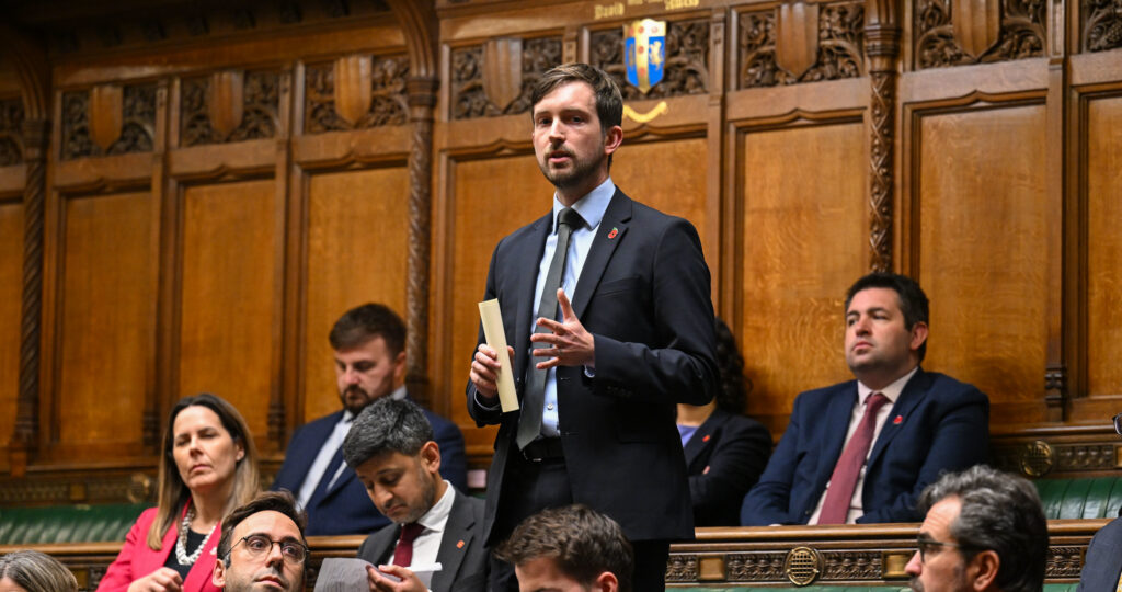 Dan Tomlinson stands in the House of Commons delivering a speech